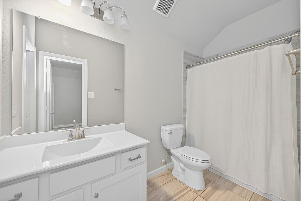 12154 Texas Trumpet Trail Humble, TX 77346 - Photo 15 of 21 a bathroom with a toilet a sink and a mirror