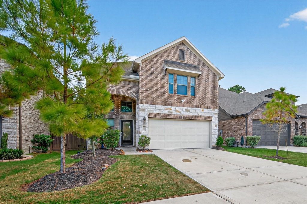 12154 Texas Trumpet Trail Humble, TX 77346 - Photo 2 of 21 a front view of a house with a yard and garage