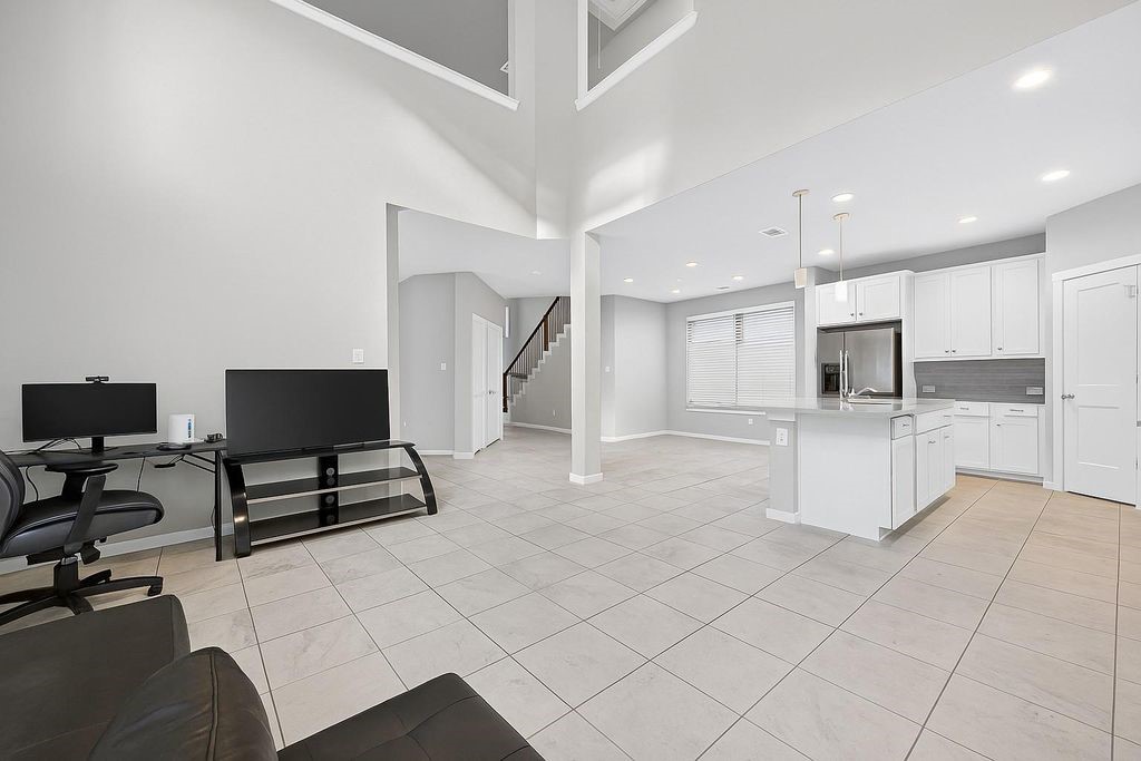 12154 Texas Trumpet Trail Humble, TX 77346 - Photo 6 of 21 a living room with furniture a flat screen tv and kitchen view