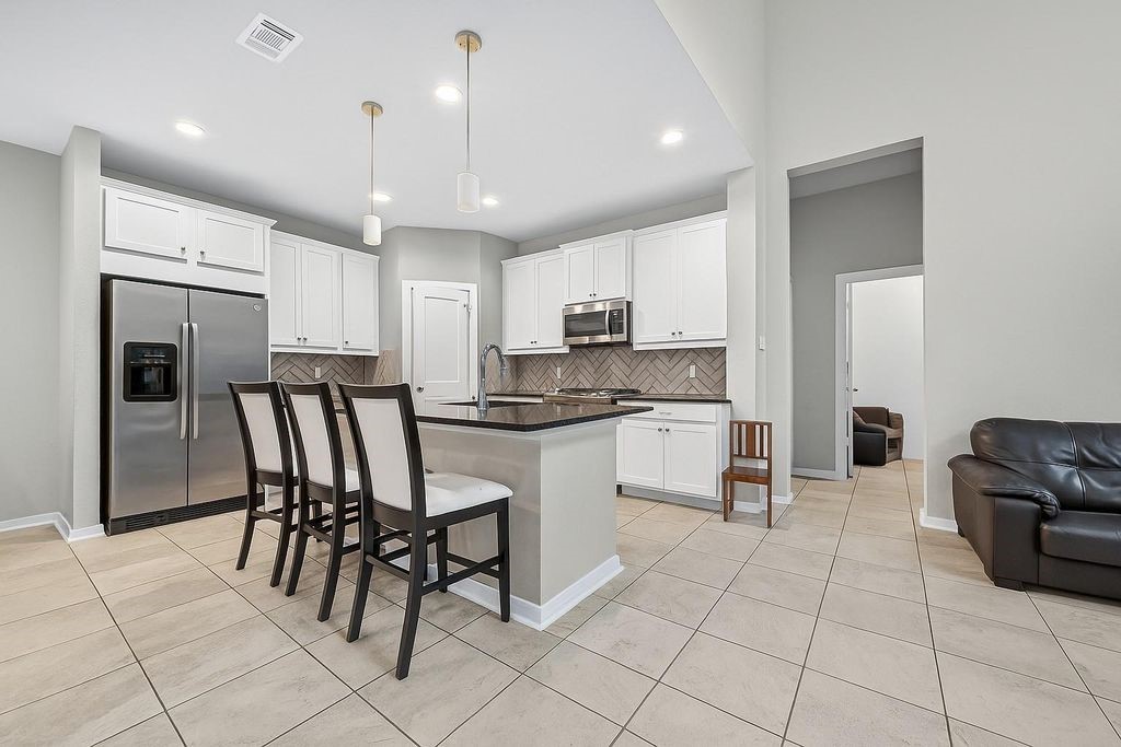 12154 Texas Trumpet Trail Humble, TX 77346 - Photo 7 of 21 a kitchen with stainless steel appliances granite countertop a refrigerator and microwave