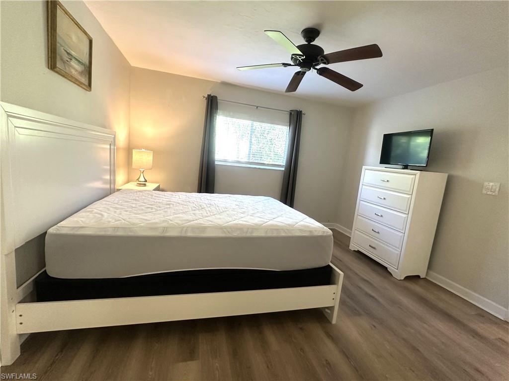 2375 Naples Trace Circle, Unit 7 Naples, FL 34109 - Photo 16 of 28 a bedroom with a bed and a flat tv screen on dresser