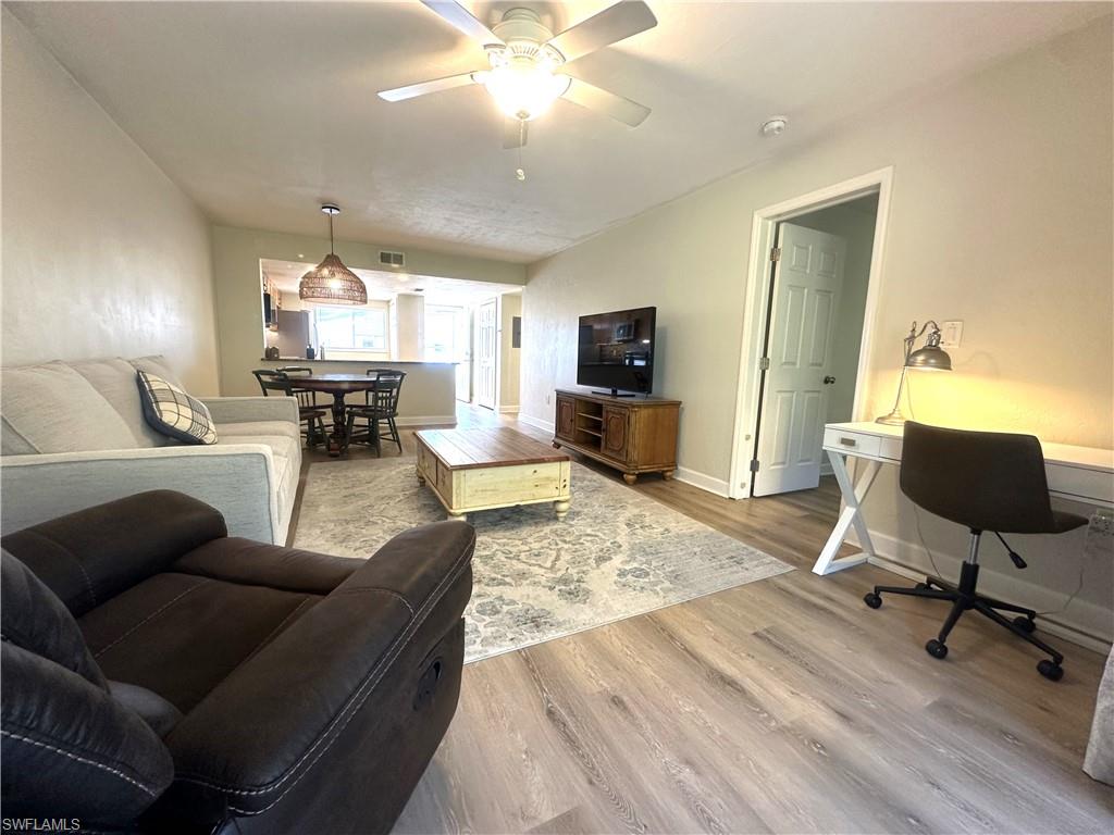 2375 Naples Trace Circle, Unit 7 Naples, FL 34109 - Photo 7 of 28 a living room with furniture and a flat screen tv