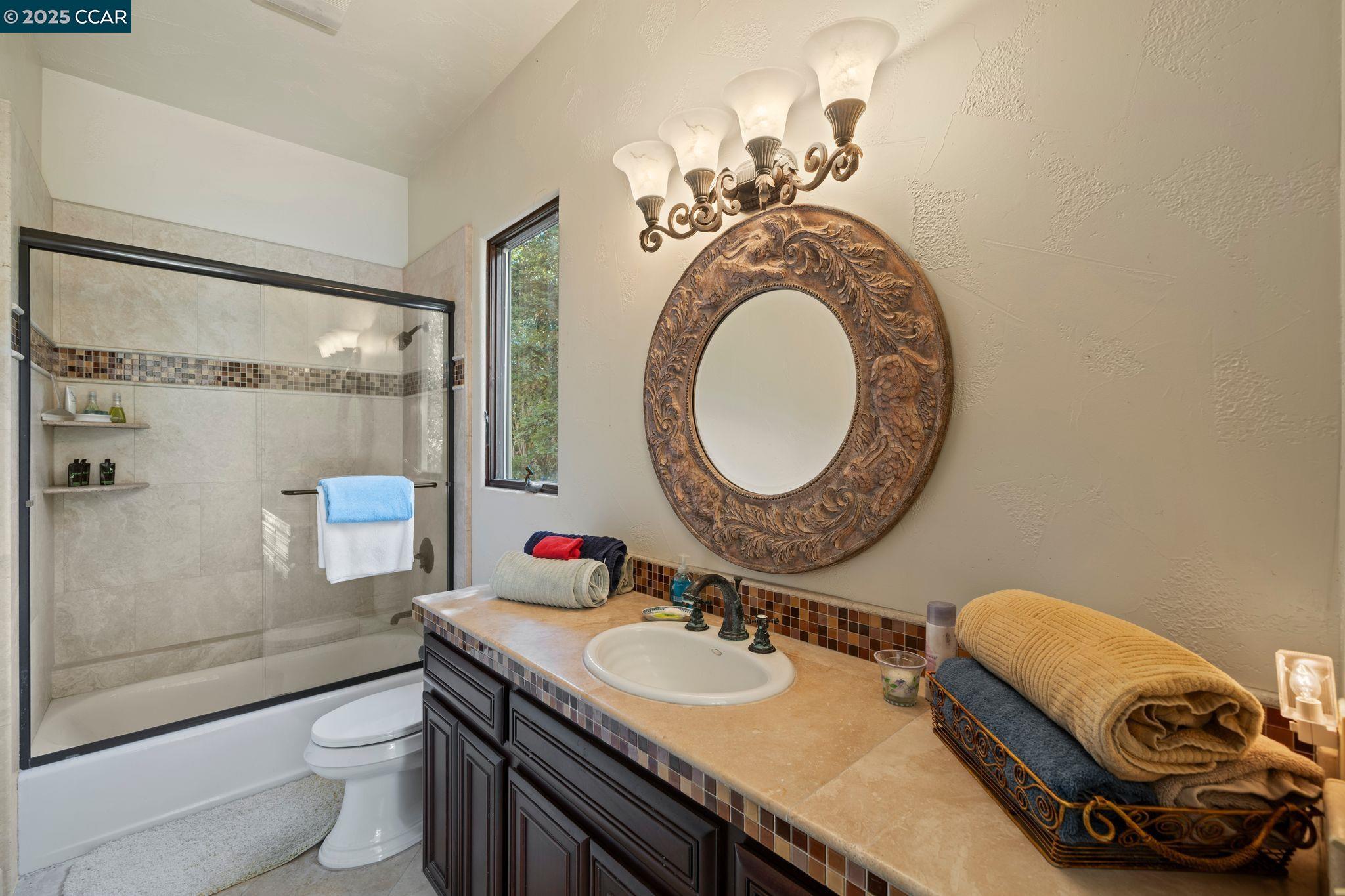 633 Kalthoff Common Livermore, CA 94550 - Photo 22 of 60 a bathroom with a granite countertop toilet a sink and a mirror