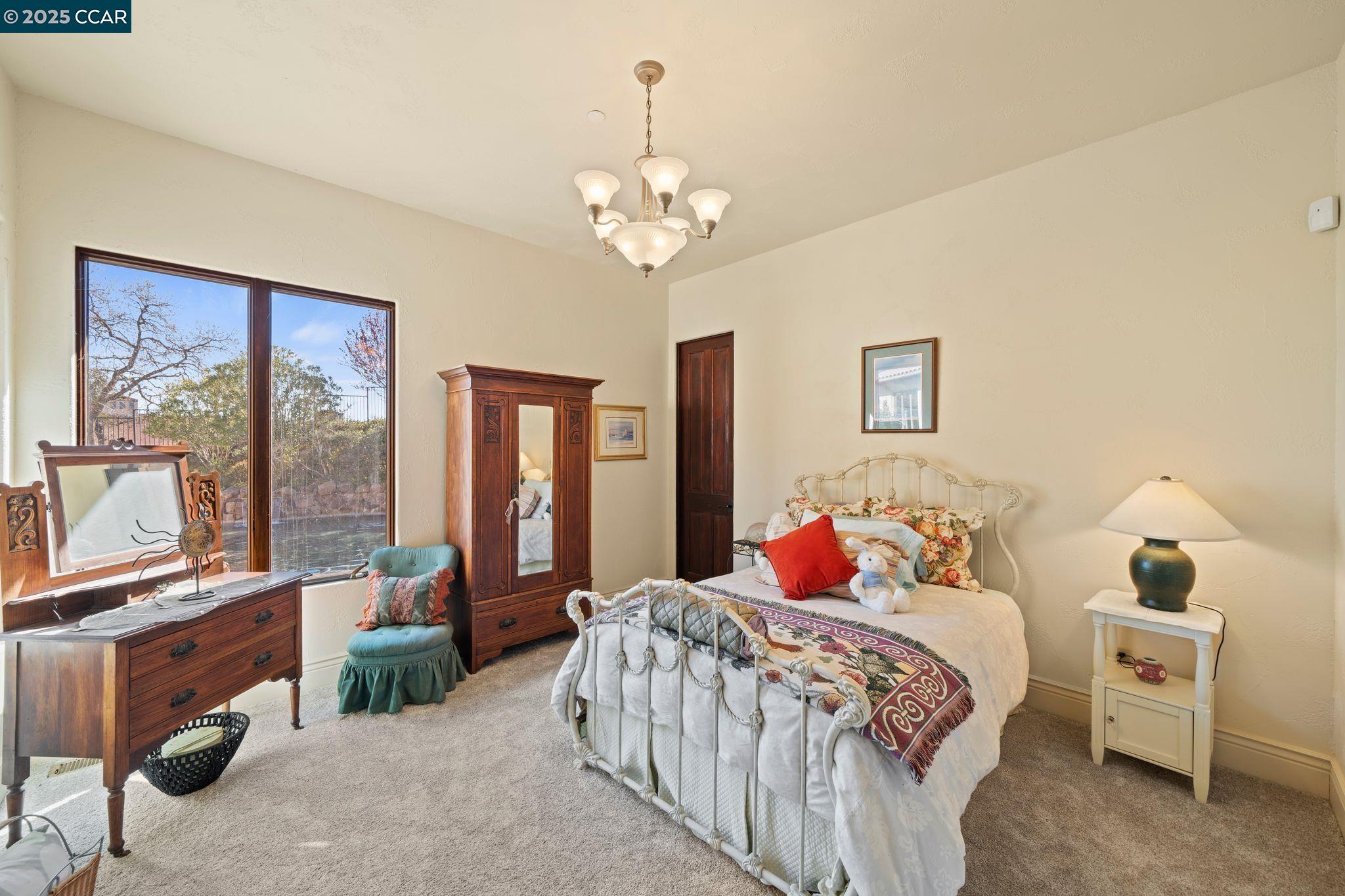 633 Kalthoff Common Livermore, CA 94550 - Photo 23 of 60 a bedroom with a large bed and a chandelier