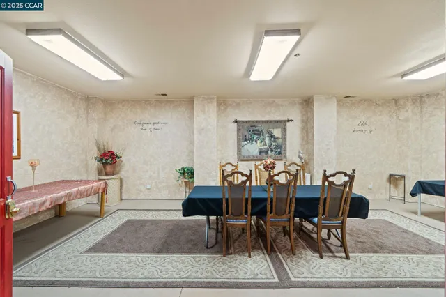 a view of a backyard with table and chairs potted plants and large tree