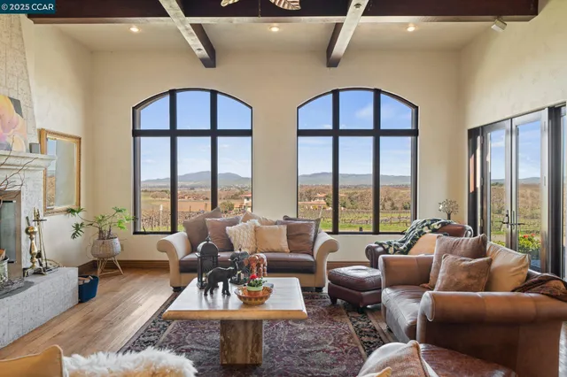 a living room with furniture and floor to ceiling windows