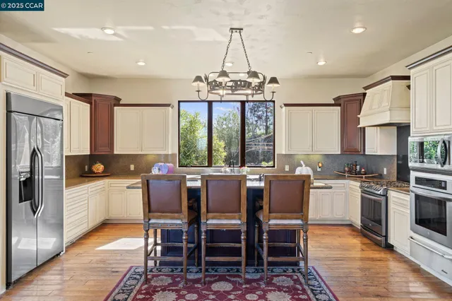 a kitchen with a dining table chairs appliances and cabinets