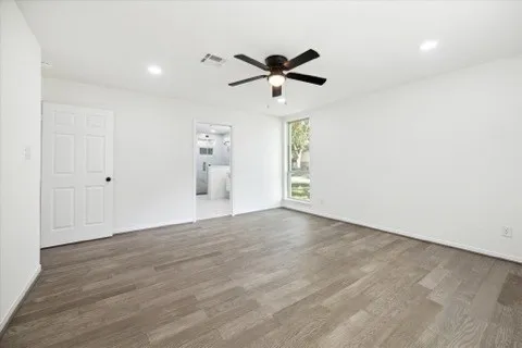 an empty room with a window and a fan