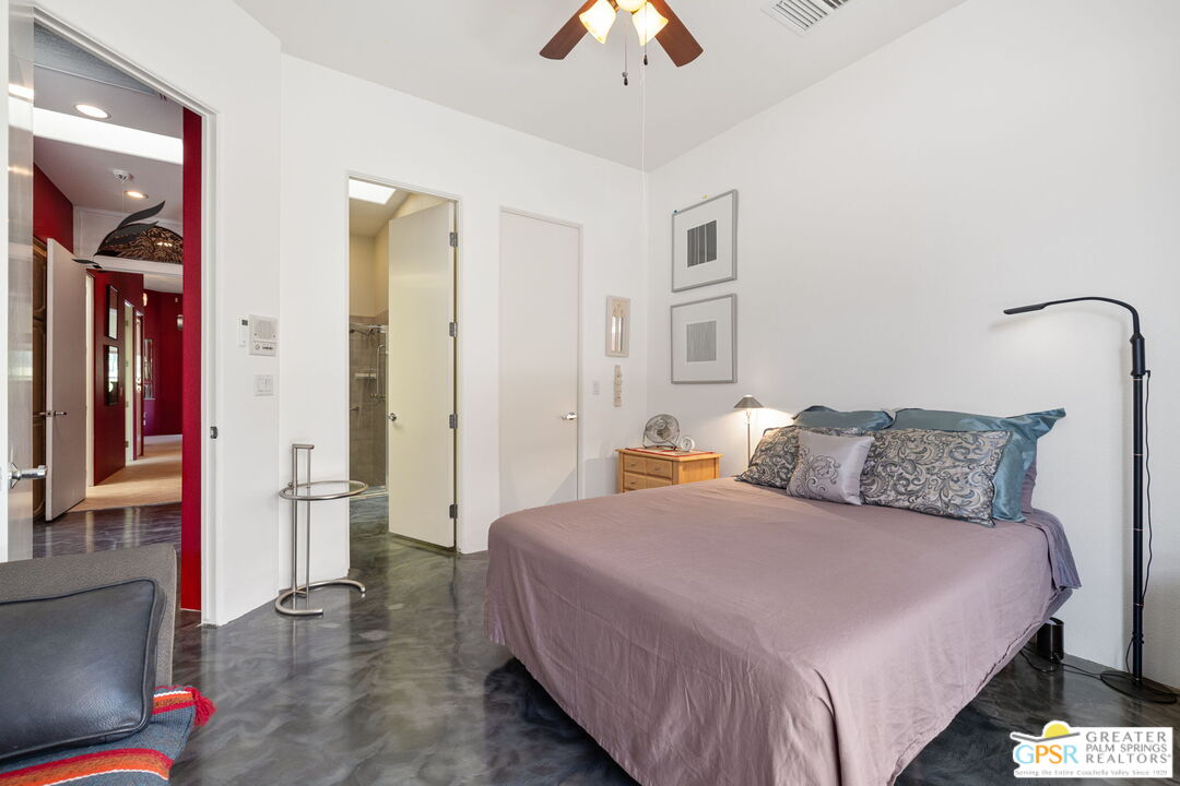 36630 Palm Court Rancho Mirage, CA 92270 - Photo 40 of 46 a spacious bedroom with a bed and a chandelier
