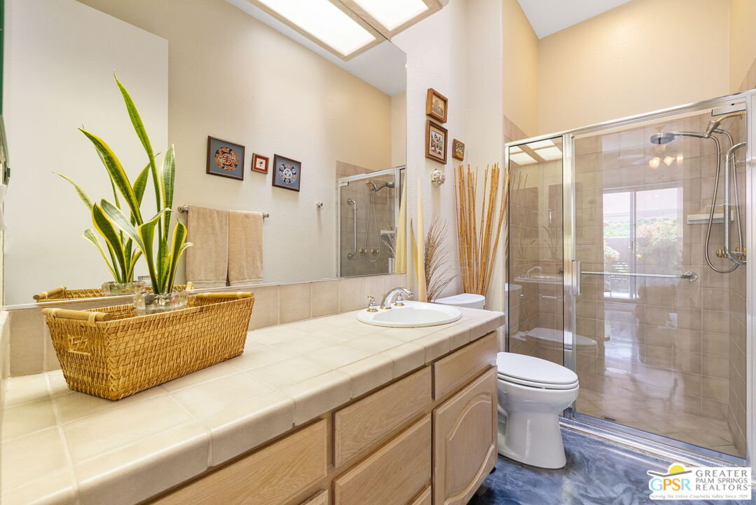 36630 Palm Court Rancho Mirage, CA 92270 - Photo 41 of 46 a bathroom with a granite countertop sink a toilet a mirror and shower