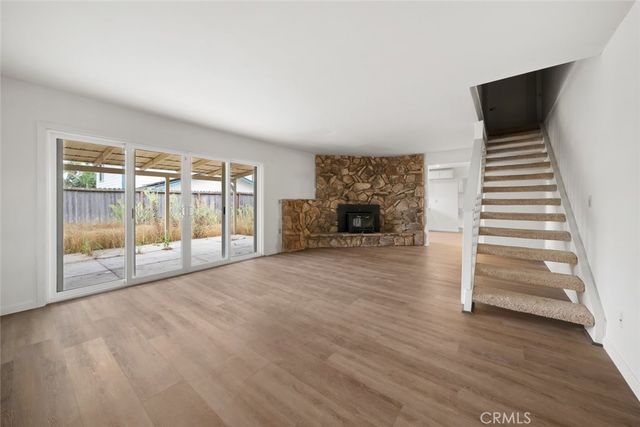 a view of empty room with wooden floor and fireplace