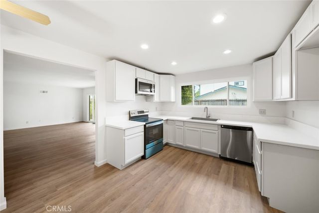 a kitchen with granite countertop a stove top oven sink and cabinets
