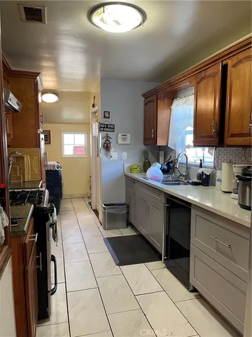 a living room with a table chairs and kitchen view