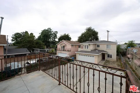 a view of a balcony with wooden floor and fence
