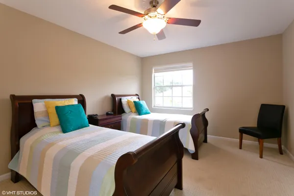 a bedroom with two beds and a chair