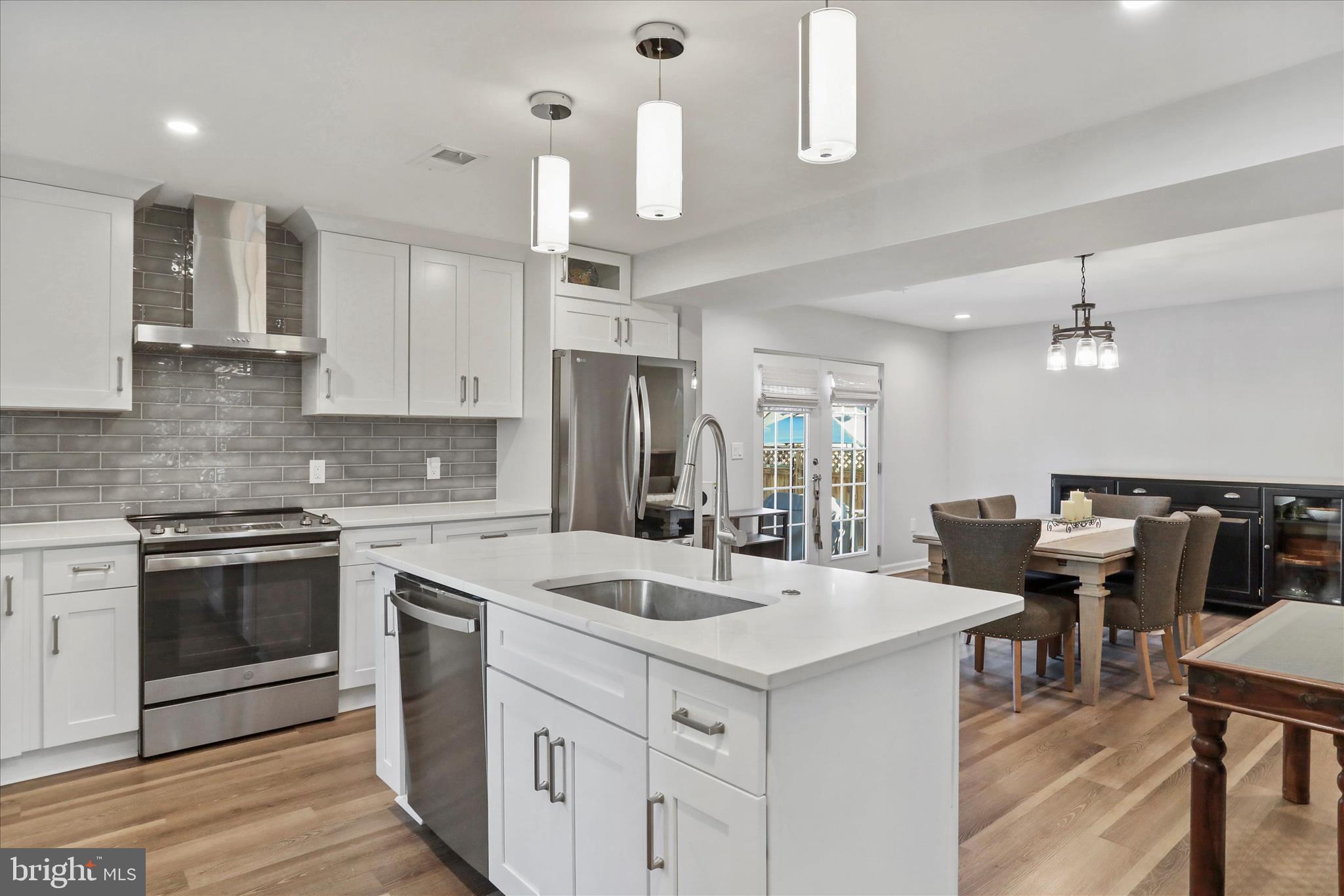 408 Blue Ridge Avenue Northeast Leesburg, VA 20176 - Photo 22 of 36 a kitchen that has a lot of cabinets in it wooden floors and white stainless steel appliances