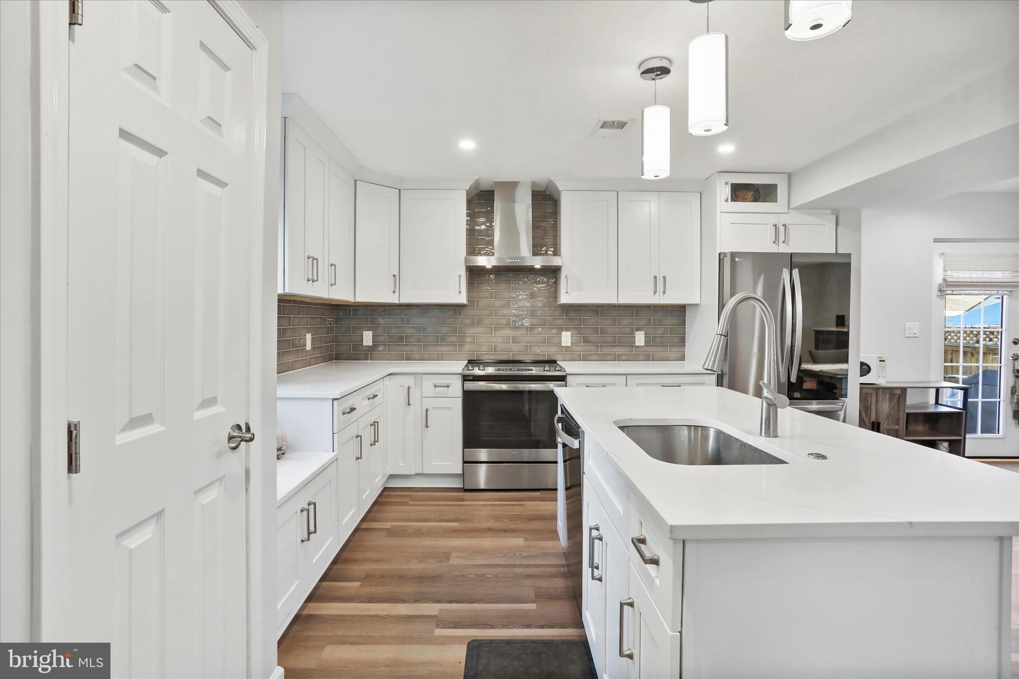 408 Blue Ridge Avenue Northeast Leesburg, VA 20176 - Photo 23 of 36 a kitchen with white cabinets and stainless steel appliances