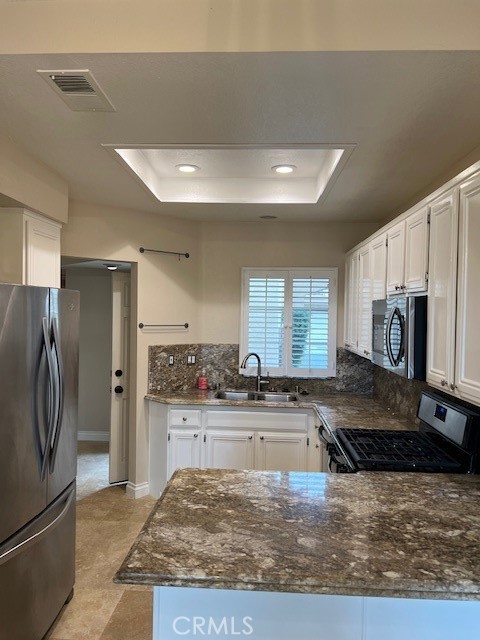 a view of a kitchen with a sink dishwasher stove and refrigerator