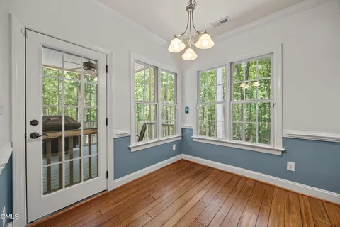 a view of a balcony with chairs and wooden floor
