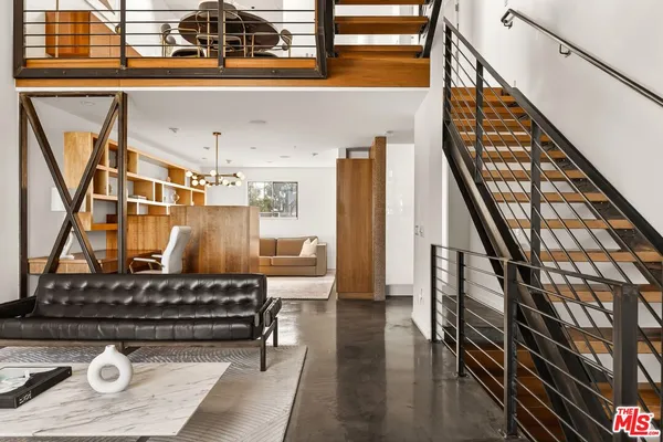 a living room with chairs and stairs
