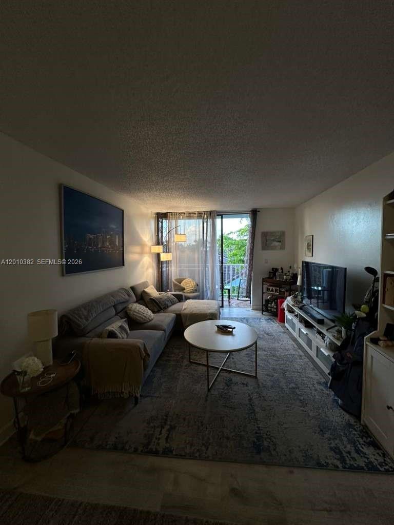 8261 Northwest 8th Street, Unit 423 Miami, FL 33126 - Photo 3 of 11 a living room with furniture and a flat screen tv