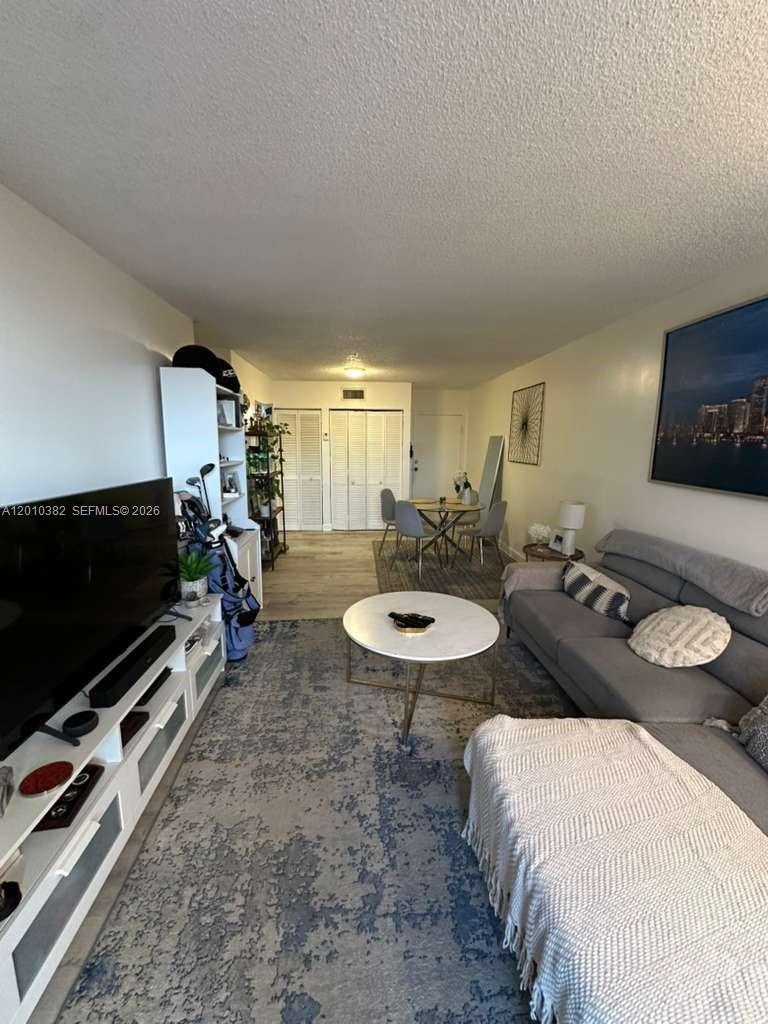 8261 Northwest 8th Street, Unit 423 Miami, FL 33126 - Photo 5 of 11 a living room with furniture and a flat screen tv