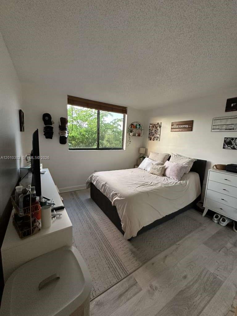 8261 Northwest 8th Street, Unit 423 Miami, FL 33126 - Photo 6 of 11 a bedroom with a bed and a couch