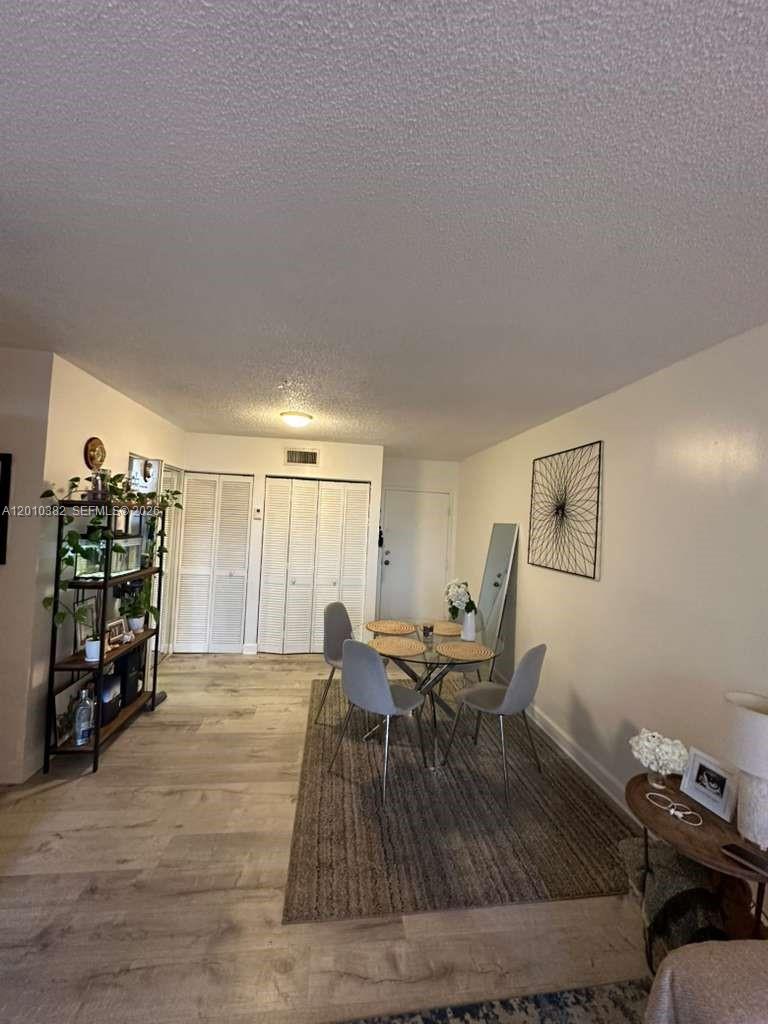 8261 Northwest 8th Street, Unit 423 Miami, FL 33126 - Photo 7 of 11 a living room with furniture and a wooden floor