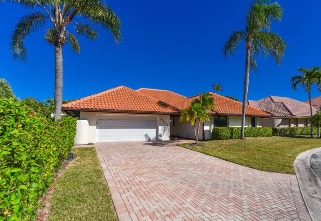 a front view of a house with a yard and potted plants