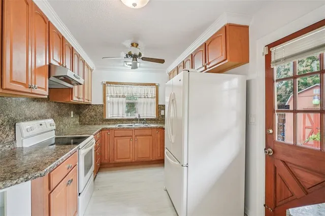 a kitchen with stainless steel appliances granite countertop a refrigerator a stove and a sink with cabinets