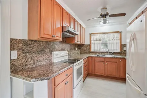 a kitchen with stainless steel appliances granite countertop a sink dishwasher stove and refrigerator