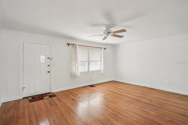 wooden floor in an empty room with a window