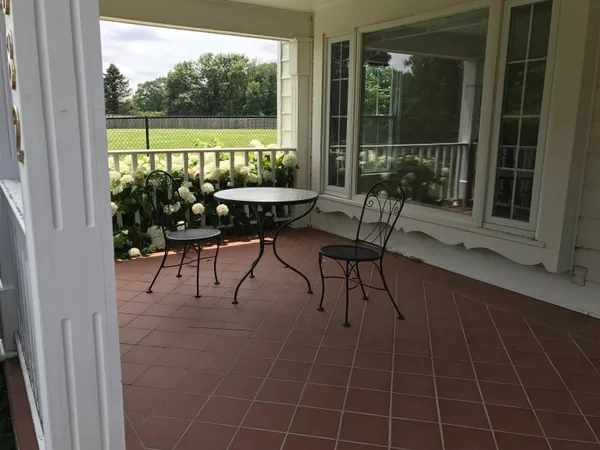 a view of a chairs and table in the balcony