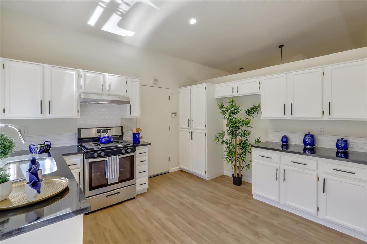 1274 Blacksmith Drive Gilroy, CA 95020 - Photo 12 of 30 a kitchen with white cabinets and wooden floor