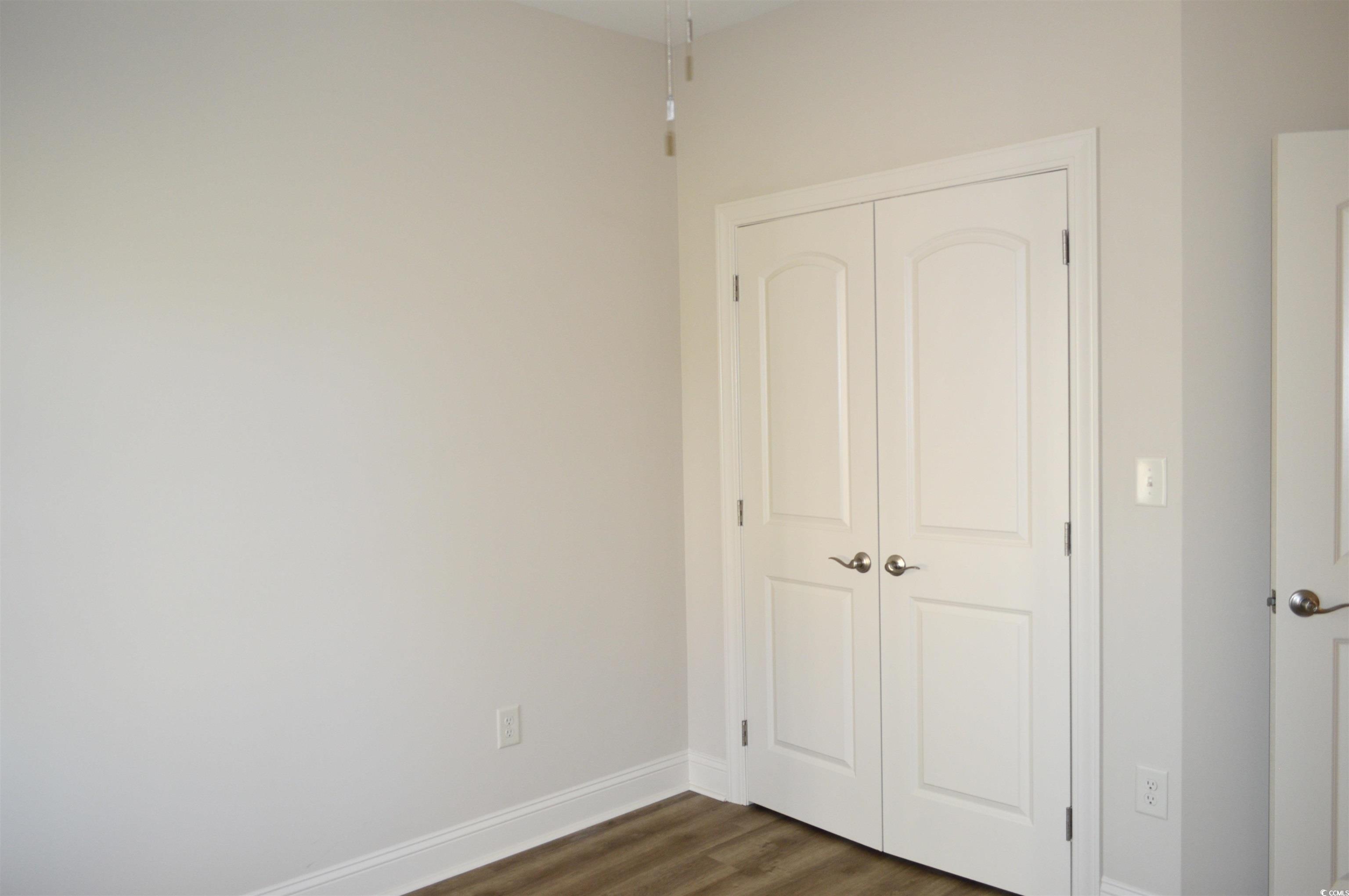 108 Hallandale Lane, Unit RIGHT Murrells Inlet, SC 29576 - Photo 22 of 35 Unfurnished bedroom featuring a closet and dark wood-type flooring