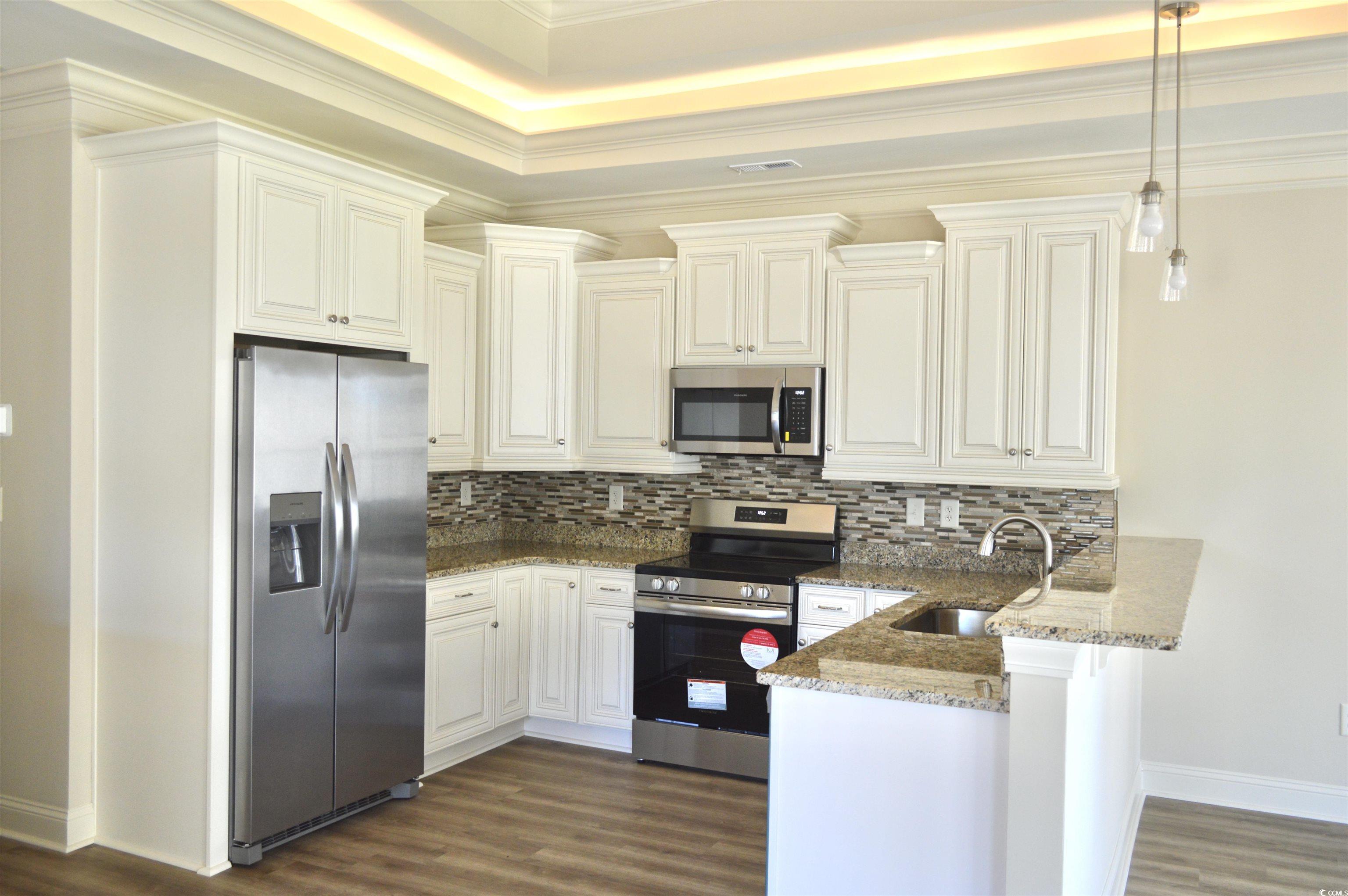 108 Hallandale Lane, Unit RIGHT Murrells Inlet, SC 29576 - Photo 8 of 35 Kitchen with light stone countertops, stainless steel appliances, sink, and pendant lighting