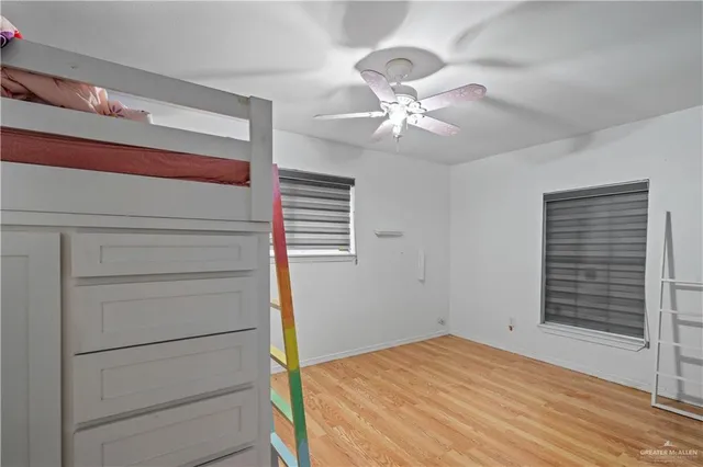 a view of a bedroom with a cabinet and a ceiling fan