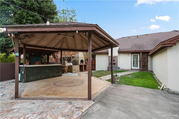 a view of a patio with table and chairs under an umbrella