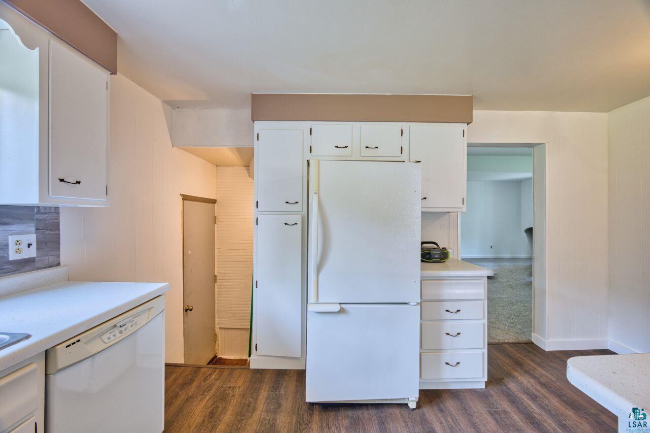 4755 Judd Road Gilbert, MN 55741 - Photo 10 of 50 Kitchen with white appliances, dark wood-type flooring, light countertops, and white cabinetry