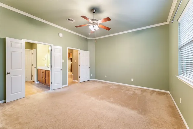 an empty room with windows and ceiling fan