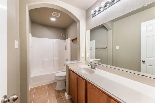 a spacious bathroom with a double vanity sink toilet mirror and bathtub