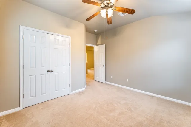 an empty room with a fan and a fan