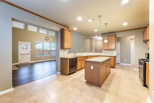 a large kitchen with a large counter top and stainless steel appliances