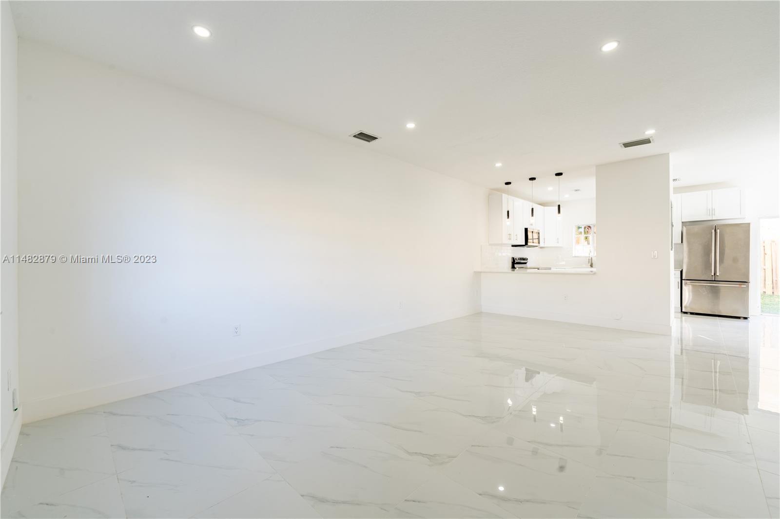 14346 Southwest 134th Place Miami, FL 33186 - Photo 12 of 36 a view of a refrigerator in kitchen and an empty room