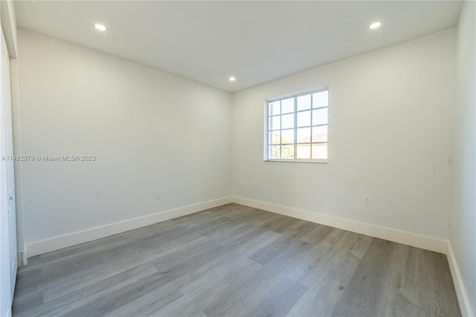 14346 Southwest 134th Place Miami, FL 33186 - Photo 17 of 36 an empty room with wooden floor and windows