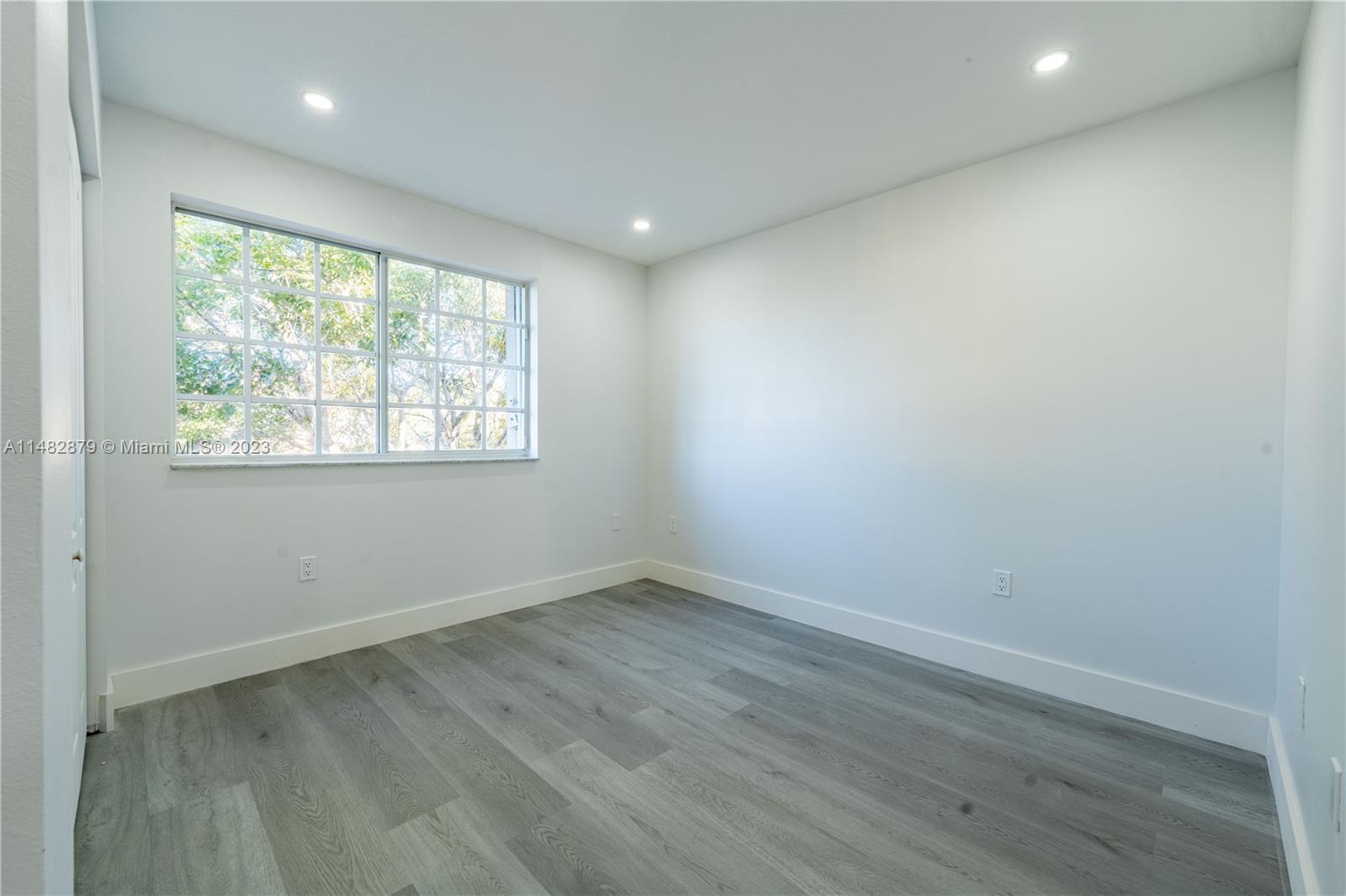 14346 Southwest 134th Place Miami, FL 33186 - Photo 18 of 36 an empty room with wooden floor and windows