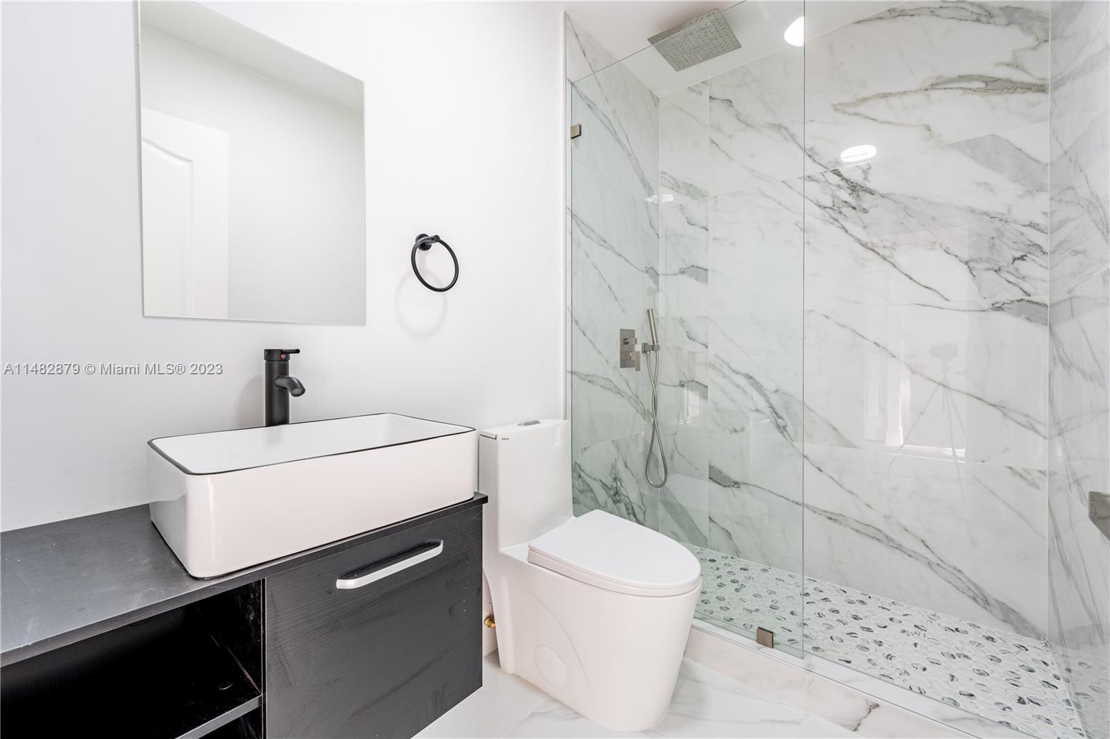 14346 Southwest 134th Place Miami, FL 33186 - Photo 19 of 36 a bathroom with a sink a toilet a shower and a mirror