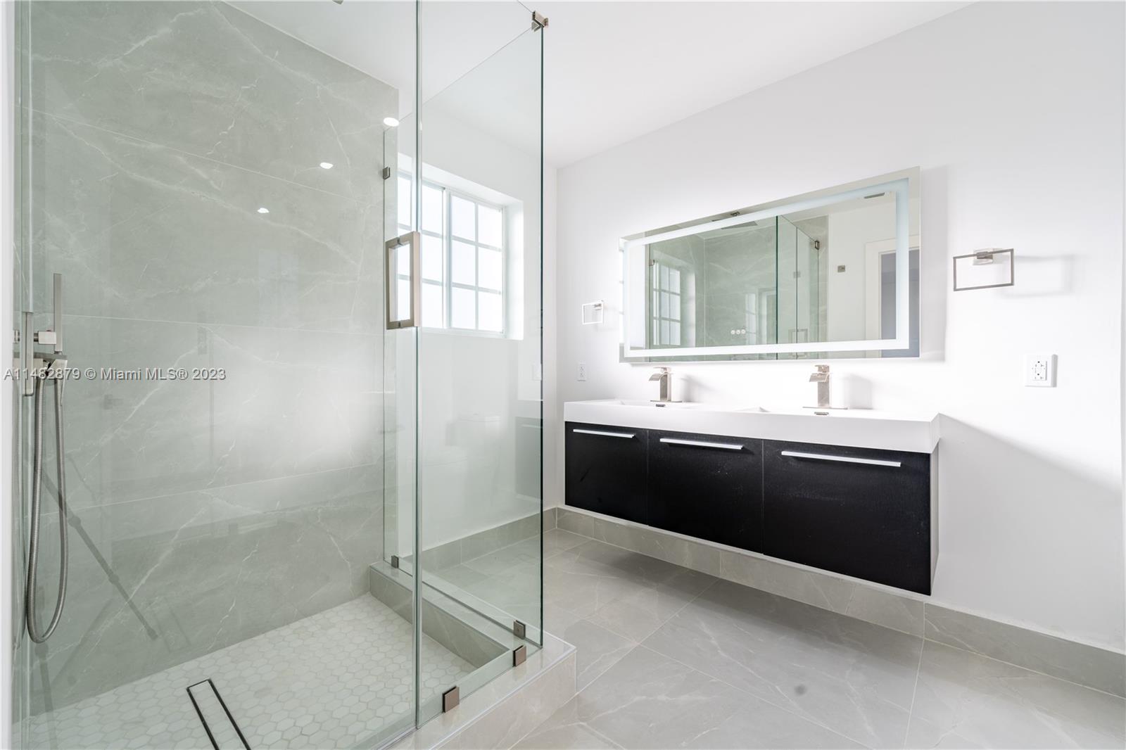 14346 Southwest 134th Place Miami, FL 33186 - Photo 21 of 36 a large bathroom with a double vanity sink a mirror and a shower