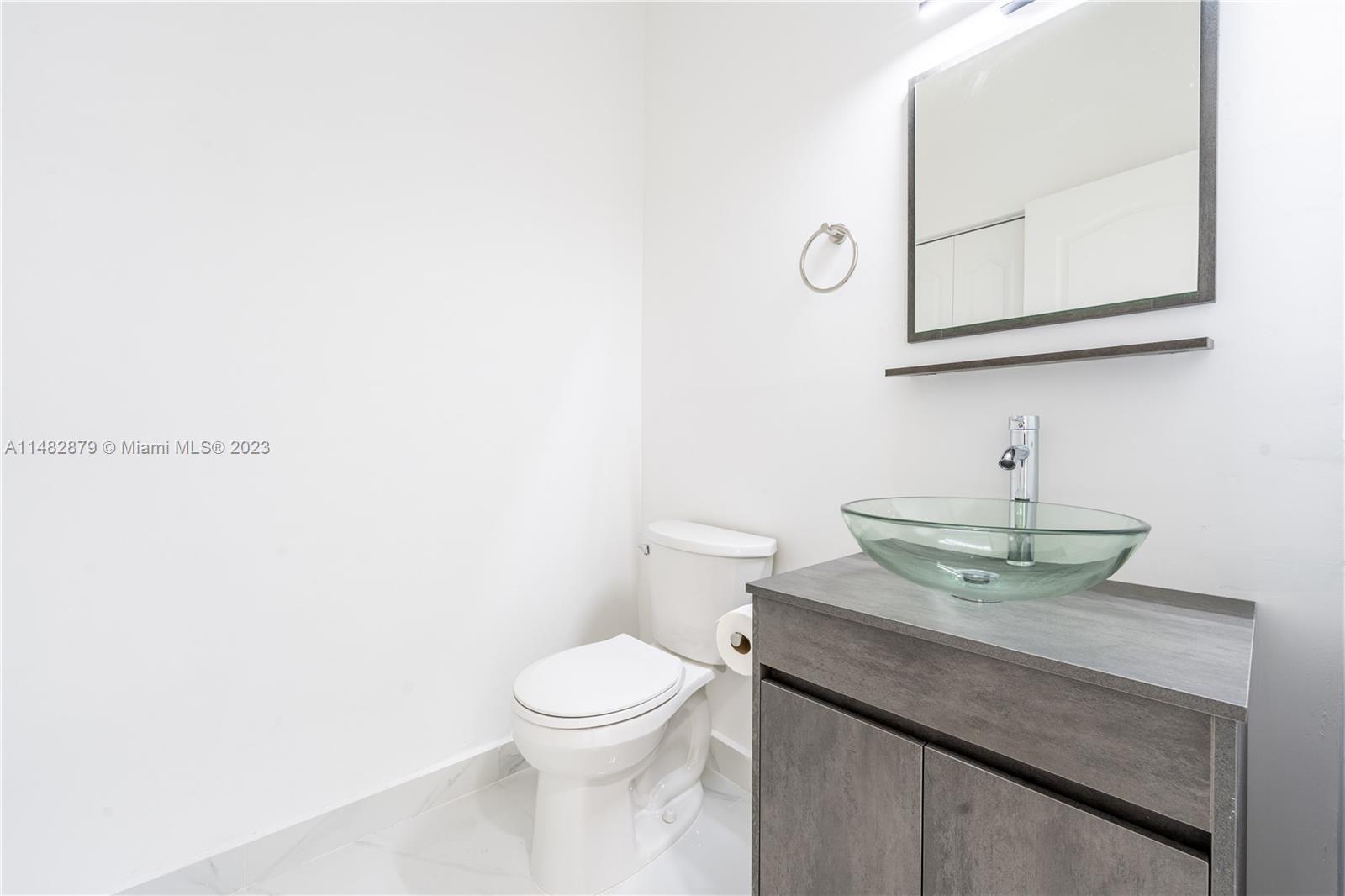 14346 Southwest 134th Place Miami, FL 33186 - Photo 24 of 36 a bathroom with a granite countertop toilet sink and mirror
