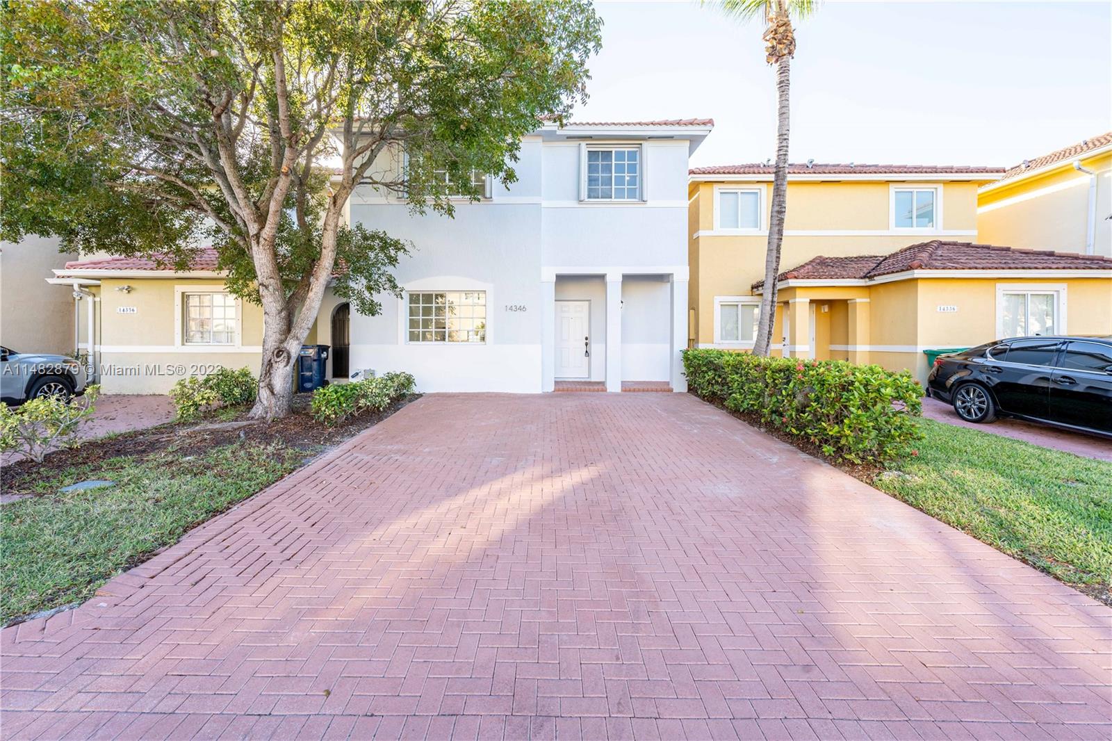 14346 Southwest 134th Place Miami, FL 33186 - Photo 3 of 36 a front view of a house with a garden and plants